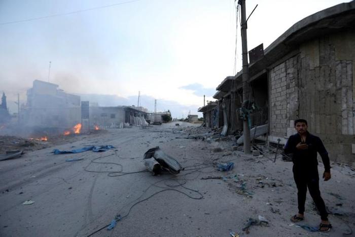 A man looks on at the site of a reported rocket attack by Syrian regime forces and their allies on the village of Kafr Nabl, south of the jihadist-held Syrian province of Idlib