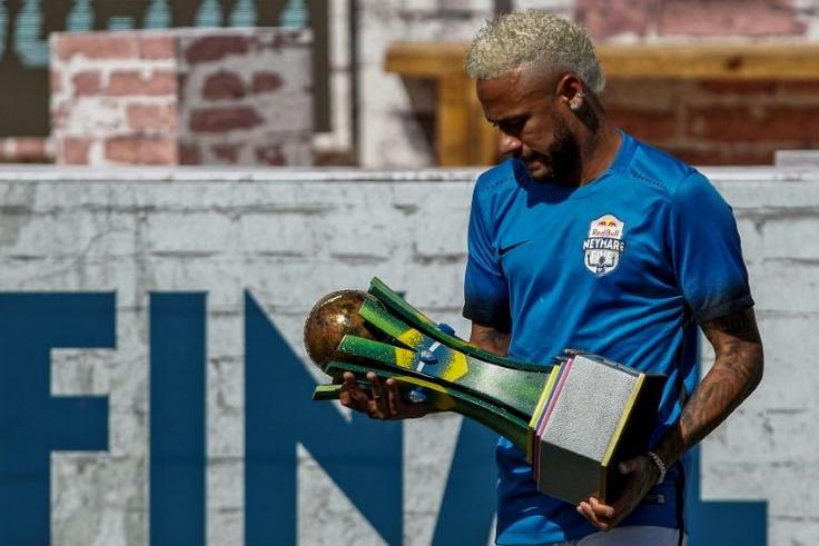Brazilian football star Neymar holds a trophy during a five-a-side football tournament for his charity Neymar Junior Project Institute in Praia Grande, Sao Paulo, Brazil, on July 13, 2019