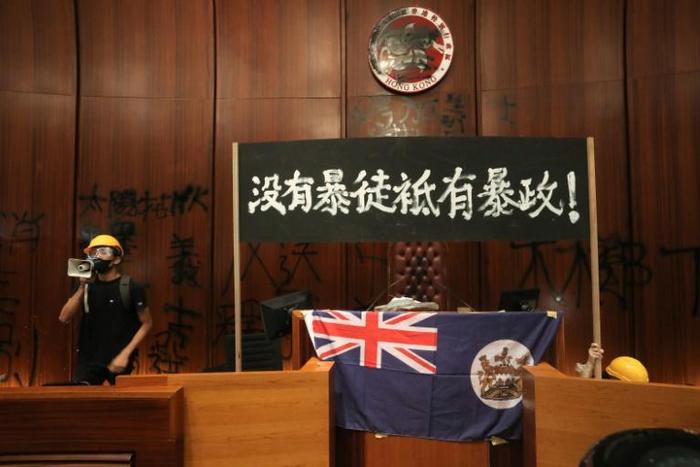 Protesters hung the city's colonial-era flag in the debating chamber, scrawled messages such as 'Hong Kong is not China' and defaced the city's emblematic seal with spray-paint