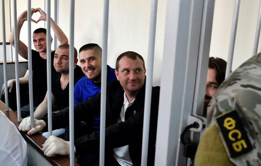 In the cramped courtroom, the sailors, who have described themselves as 'prisoners of war', were held in a metal-barred cage reserved for defendants