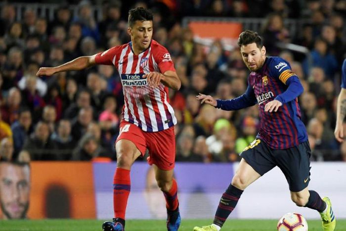 Atletico Madrid's Rodrigo Hernandez tussling with Barcelona striker Lionel Messi in April.