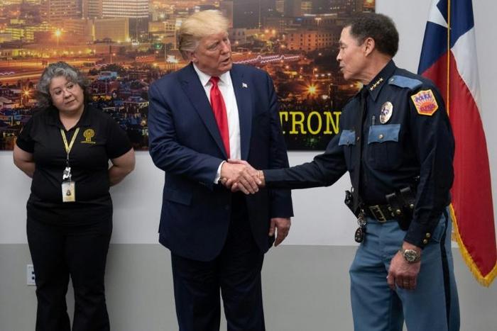 US President Donald Trump shakes hands with El Paso Police Chief Greg Allen (R) before greeting first responders in the wake of the massacre of 22 people at a local Walmart