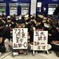 Protesters hold placards during a sit-in at Yuen Long MTR station in Hong Kong