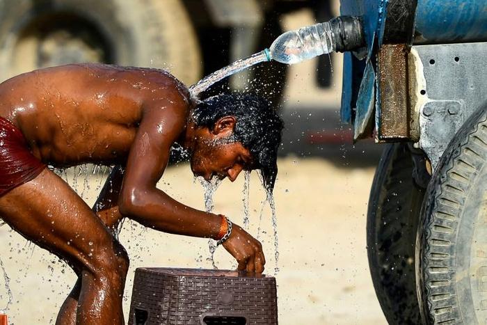 An Indian truck driver takes a cooling bath in Allahabad, where temperatures have neared 50 degrees Celsius (122 Fahrenheit)