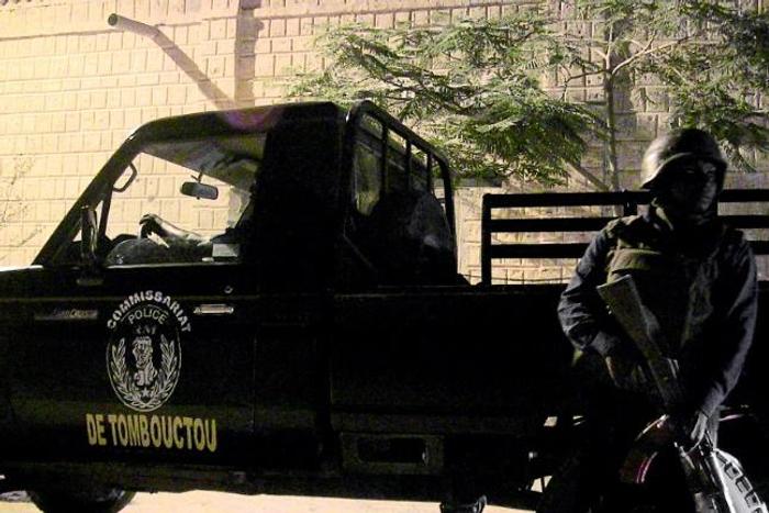 A Malian policeman stands next to a police car in Timbuktu during a joint patrol with UN peacekeepers in 2016