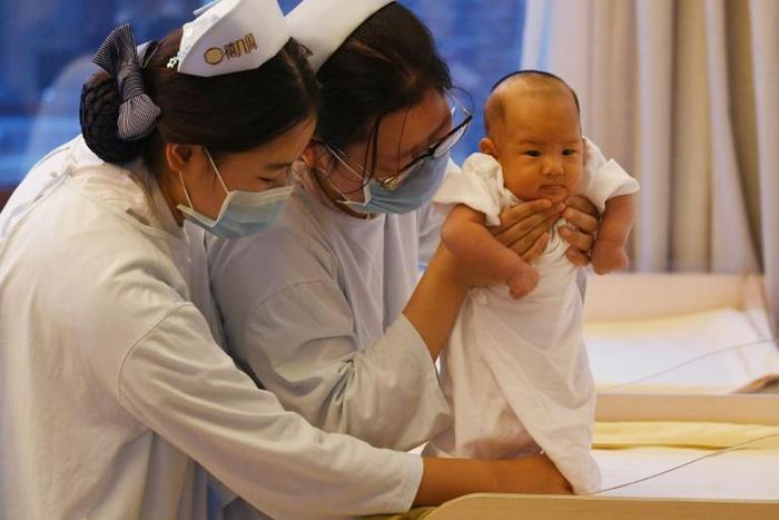 Nurses hold a baby at a birth center in Beijing in December 2016