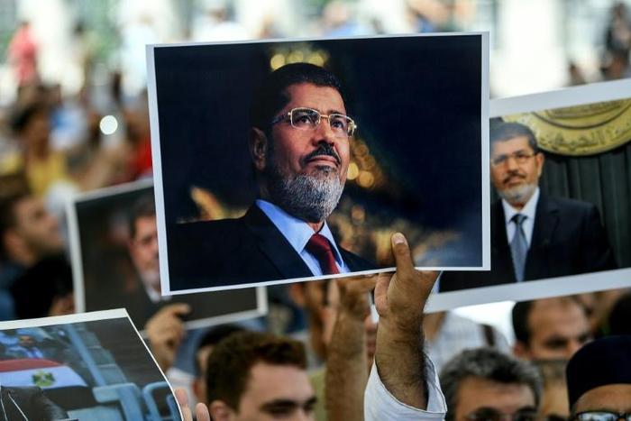 People hold picture of Egyptian President Mohamed Morsi during a symbolic funeral cerenomy on June 18, 2019 at Fatih mosque in Istanbul