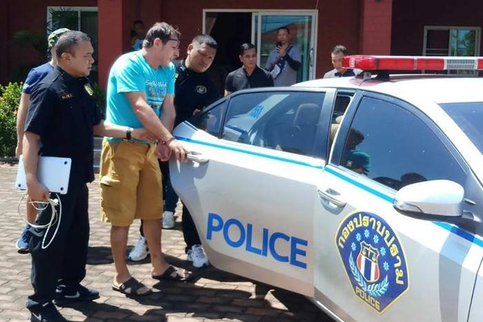 Italian national Francesco Galdelli is taken into custody by Thai police after being arrested on charges he posed as actor George Clooney to sell clothes online