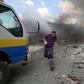 A rescuer from the Violet NGO runs during airstrikes by Syrian regime forces in Maar Shurin on the outskirts of Maarat al-Numan in northwest Syria on July 16, 2019