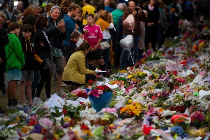 People pay their respects at a memorial site at the Botanical garden in Christchurch on March 18, 2019, three days after a shooting incident at two mosques in the city that claimed the lives of 51 Muslim worshippers