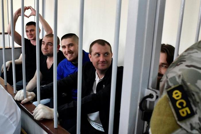 In the cramped courtroom, the sailors, who have described themselves as 'prisoners of war', were held in a metal-barred cage reserved for defendants