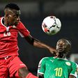 Kenya midfielder Philemon Otieno (L) heads the ball next to Senegal's forward Sadio Mane