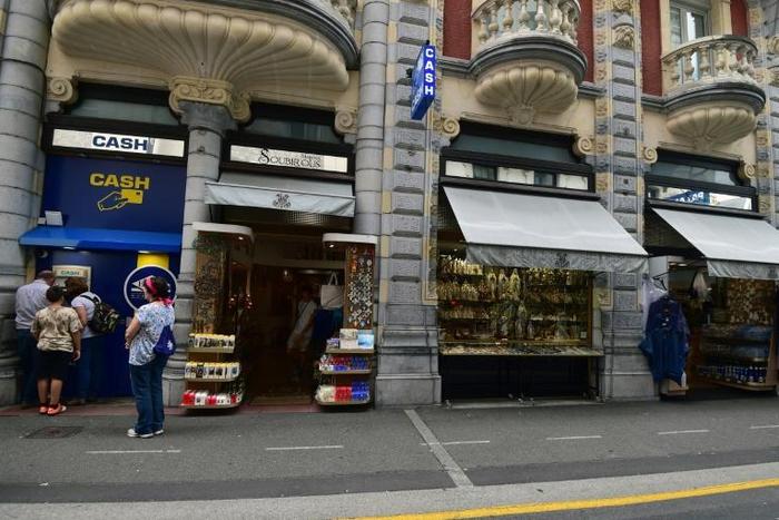 Pope Francis says he wants to see less commercialism and more piety in the Marian shrine in the French southwestern pilgrimage city of Lourdes. Visitors wait to withdraw money from a cash dispenser next to shops selling religious articles