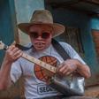 Malawi's musician with albinoism Lazarus Chigwandali practices his guitar and drum in front of his children before leaving his home to perform on the streets of Lilongwe