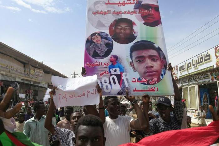 Sudanese protesters march with a poster bearing the portraits of victims, who were shot dead for protesting against a shortage of bread, during a demonstration in the central city of Al-Obeid on July 31, 2019.Hundreds of protesters marched through a ce...