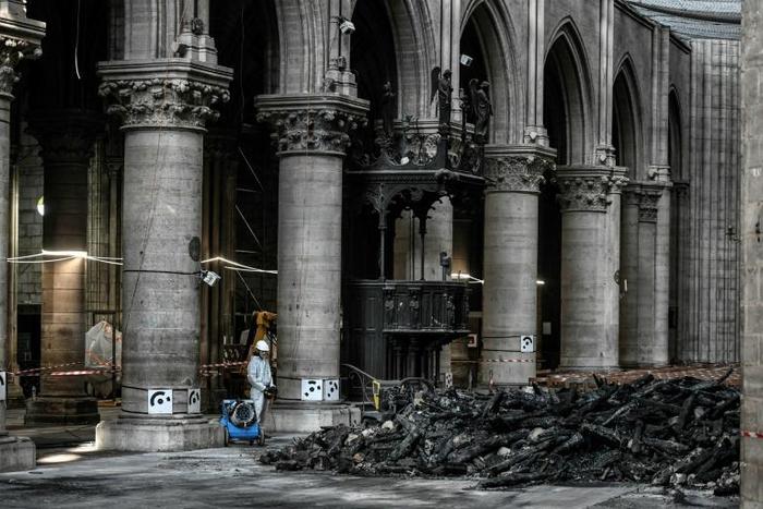 Instead of crowds, only a few dozen specialist workers wearing white protective overalls, hard hats and masks could be seen carrying out painstaking work to make the building safe