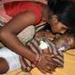An Indian child suffering from Acute Encephalitis Syndrome is comforted at the Sri Krishna Medical College and Hospital in Bihar. Over 100 children have died of the lychee-linked virus this month alone