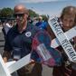 Antonio Basco (R) holds the cross of his common-law wife Margie Reckard who died in the El Paso shooting, as he walks to a makeshift memorial after the shooting that left 22 people dead