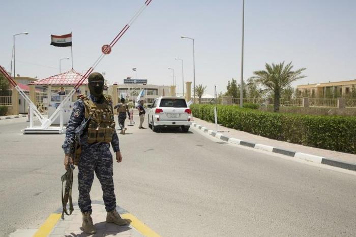 Iraqi soldiers guard the entrance of an oil fied in Basra, an oil-rich province where US companies including ExxonMobil and Baker Hughes are operational