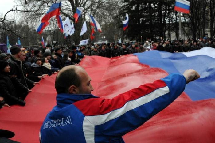Pro-Russian demonstrators carry a giant Russian flag as they rally in central Simferopol on February 27, 2014