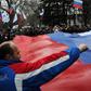 Pro-Russian demonstrators carry a giant Russian flag as they rally in central Simferopol on February 27, 2014