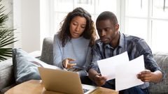 Serious African American couple discussing paper documents