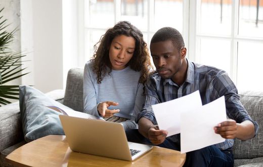 Serious African American couple discussing paper documents