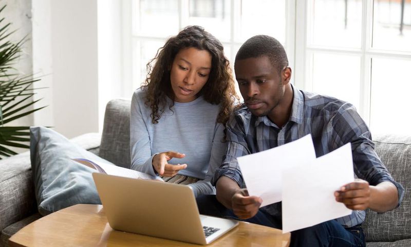 Serious African American couple discussing paper documents