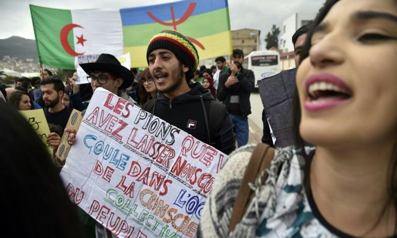 Protesters carry the Algerian flag (L) and the Berber colours side by side at a rally in March against veteran president Abdelaziz Bouteflika in the city of Bejaia east of the capital Algiers