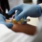 A technician extracts blood from a patient for an HIV test at the specialized Condesa Clinic in Mexico City on July 18, 2019, three days before the opening in the city of an international conference on HIV science