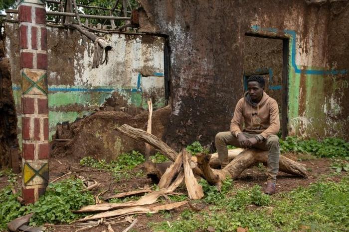 Teketel Memhiru sits by the ruins of his house, burned down during ethnic clashes at Cherqo village