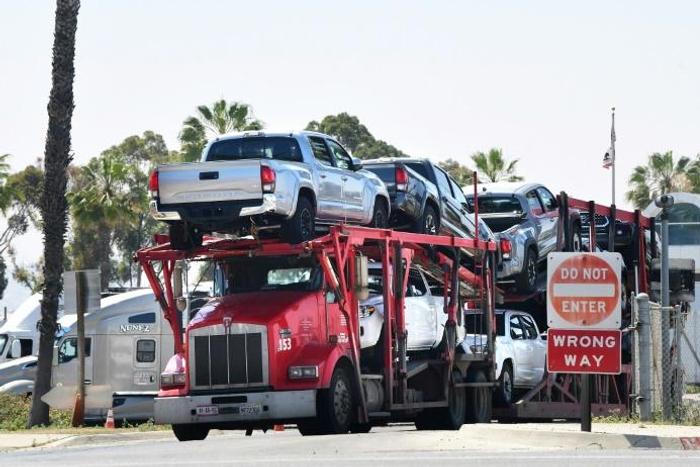 A truck loaded with vehicles enters the US at the Otay Mesa port of entry at the US-Mexico border in San Diego, California on June 8, 2019