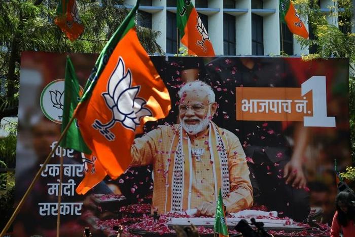 A billboard with an image of Indian Prime Minister Narendra Modi is surrounded by Bharatiya Janata Party (BJP) flags