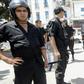 In this file photo from June 2012, a Tunisian woman, wearing a niqab, walks in front of police officers after Friday prayers