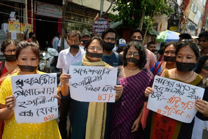 Indian supporters of the Bharatiya Janata Party hold placards June 10, 2019, as they observe a silent protest against recent violence in West Bengal