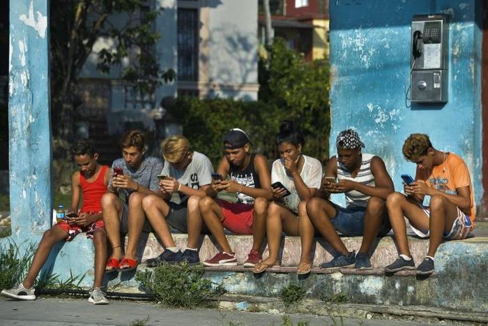 Young Cubans connect to the internet from their mobile phone in Havana, on June 6, 2019