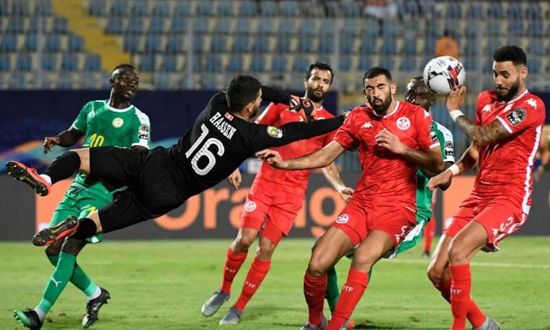 Dylan Bronn (R) of Tunisia concedes the own goal that gave Senegal victory in an Africa Cup of Nations semi-final in Cairo