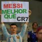 A fan of Argentina displays a placard reading "Messi better than CR7" at the start of the Copa America match against Paraguay in June