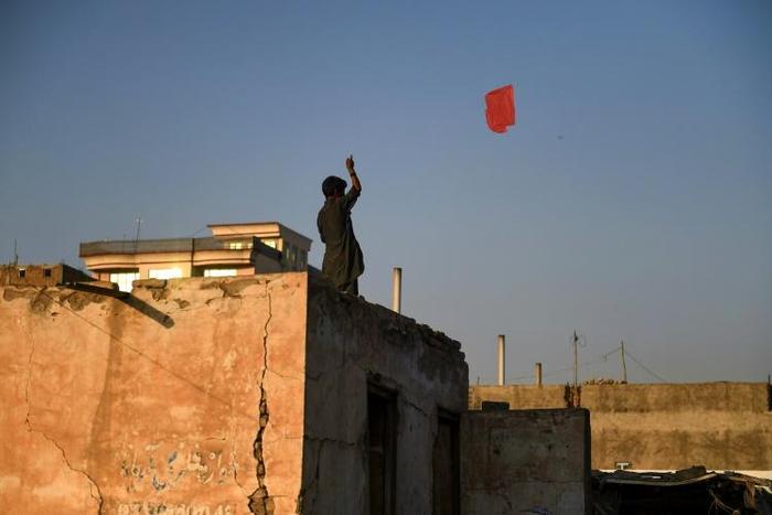 An Afghan boy flies a kite from the rooftop of a house in Mazar-i-Sharif. Young people are sceptical a deal with the Taliban will bring lasting peace