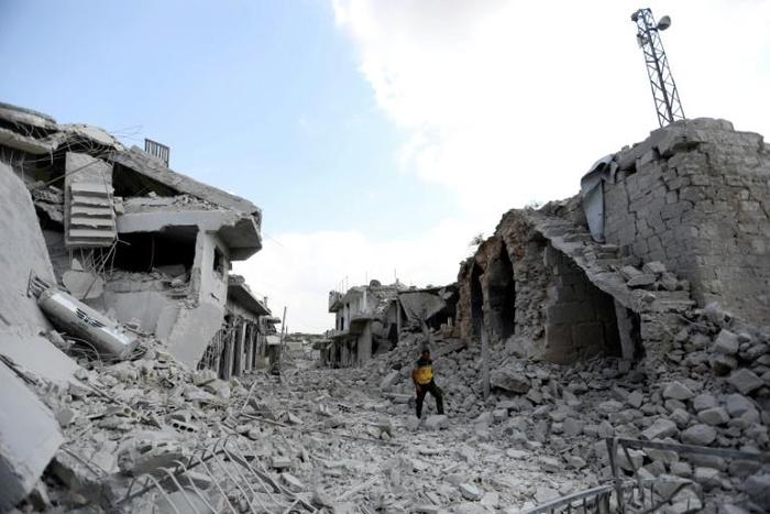 A man walks amid the debris of destroyed buildings in the town of Ihsim, in Syria's Idlib region, on June 14, 2019