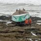 After capsizing, it ended up upside down on the rocky shore