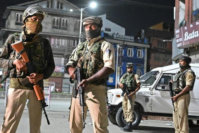 Indian paramilitary troopers stand guard at a roadblock in Srinagar, the capital of Indian-administered Kashmir, where state authorities forbade movement and ordered educational institutions shut, as tensions rose with Pakistan