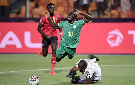 Uganda goalkeeper Denis Onyango fouls Senegal forward Sadio Mane, whose penalty kick was saved in an Africa Cup of Nations last-16 match in Cairo