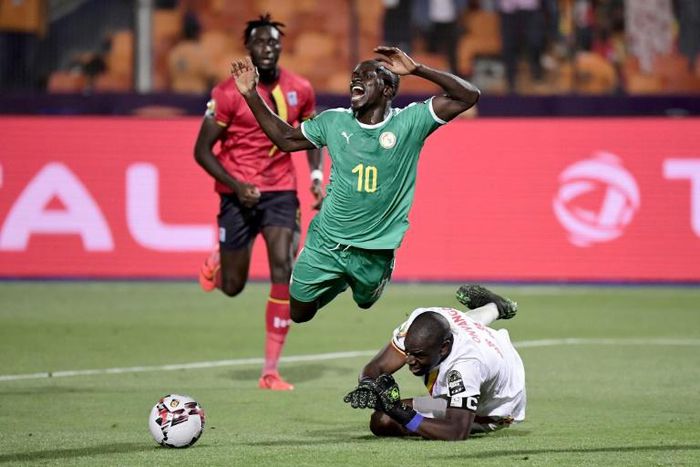 Uganda goalkeeper Denis Onyango fouls Senegal forward Sadio Mane, whose penalty kick was saved in an Africa Cup of Nations last-16 match in Cairo