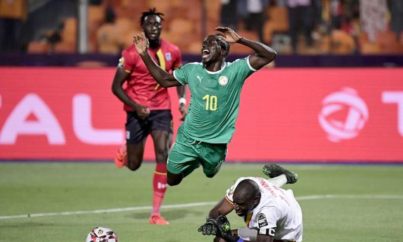 Uganda goalkeeper Denis Onyango fouls Senegal forward Sadio Mane, whose penalty kick was saved in an Africa Cup of Nations last-16 match in Cairo