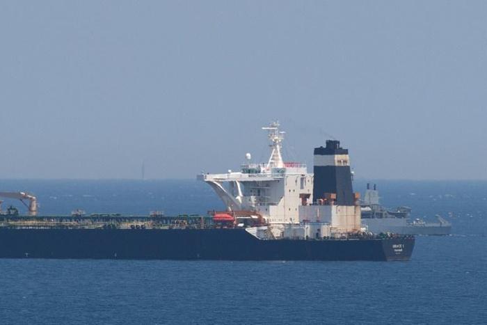 A British Royal Navy ship (back R) patrols near supertanker Grace 1 suspected of carrying crude oil to Syria in violation of EU sanctions after it was detained off the coast of Gibraltar on July 4, 2019