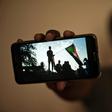 Sudanese protester Akram, who prefers to keep his identity hidden, shows a picture from a sit-in brutally cleared by men wearing military fatigues on June 3