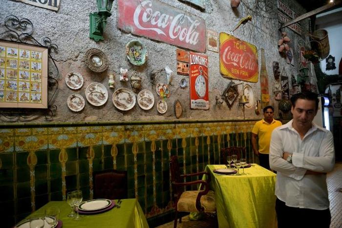 A waiter waits for clients at San Cristobal restaurant in Havana, enduring a slowdown blamed on new US sanctions