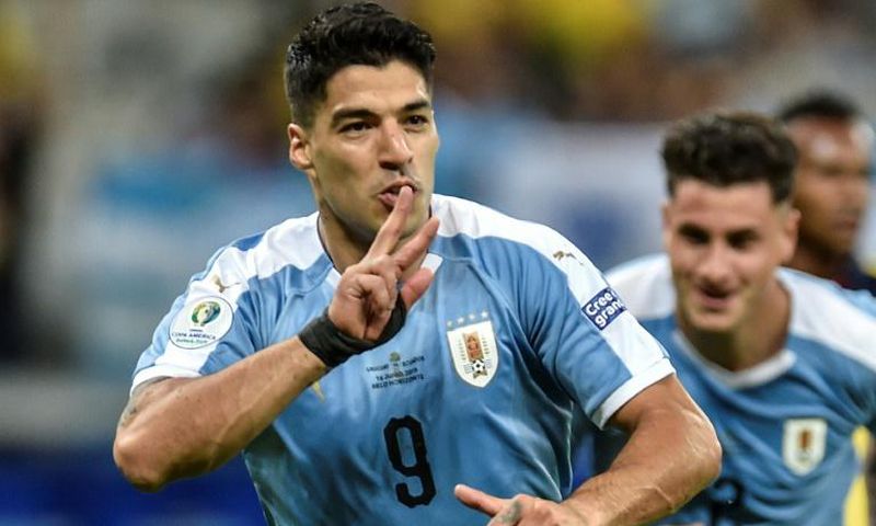 Luis Suarez wheels away in celebration after netting Uruguay's third goal following a flick-on by Martin Caceres