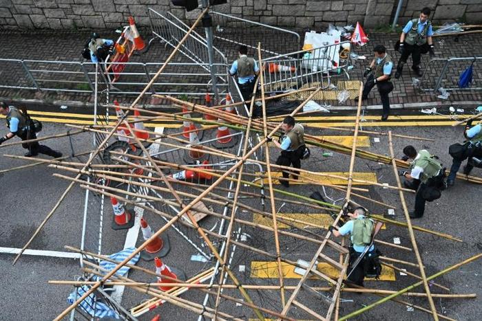 Police officers dismantle barricades built by demonstrators in Hong Kong on June 12 protesting against government plans to allow extraditions to mainland China